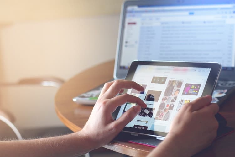 Browsing an online store on a tablet in front of a laptop