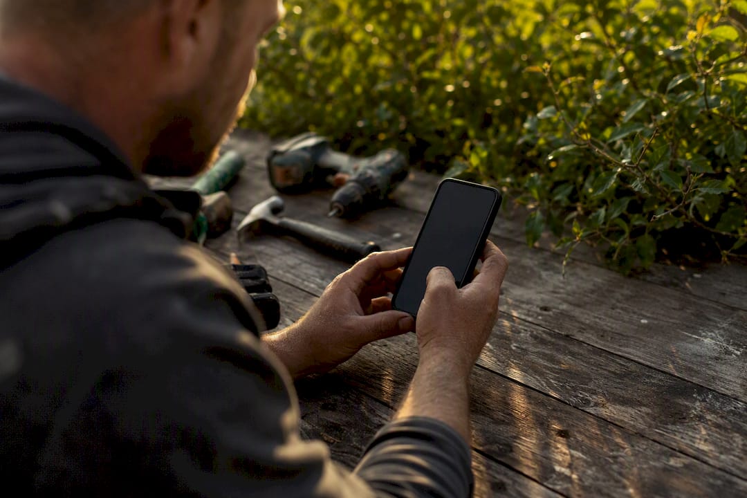 Tradie entering details on smartphone